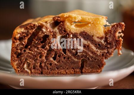 Tarte zèbre chocolat et vanille avec morceau coupé sur plaque. Gâteau au chocolat en marbre fait maison Banque D'Images