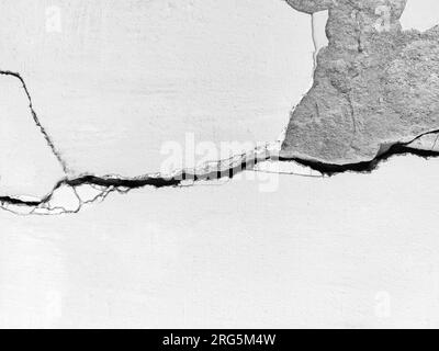 Grande longue fissure tortueuse sur le mur. Destructions sur le mur d'un ancien bâtiment. Espace de copie. Photo noir et blanc. Mise au point sélective. Banque D'Images