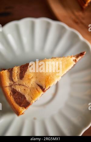 Tarte zèbre chocolat et vanille avec morceau coupé sur plaque. Gâteau au chocolat en marbre fait maison Banque D'Images