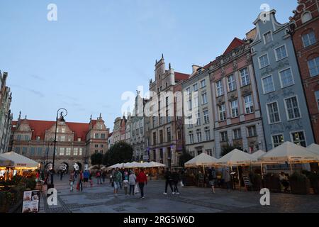 Maisons historiques et la porte verte le long du long marché ( Długi Targ) à Gdansk, Pologne ; terrasses avec parasols Banque D'Images