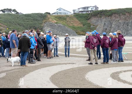 Denny Dyke, artiste du labyrinthe de sable, et son équipe s'adressent à la foule avant le début d'un cercle dans la promenade du labyrinthe de sable à Bandon, Oregon. Banque D'Images