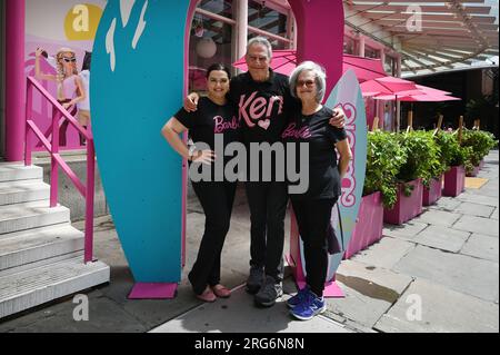 New York, États-Unis. 07 août 2023. Les personnes portant des chemises Barbie et Ken posent devant le Malibu Barbie Cafe à New York, NY, le 7 août 2023. Le film récemment sorti "Barbie", réalisé par Greta Gerwig, a atteint 1 milliards de dollars en ventes de billets au box-office, car «l'effet Barbie» a des entreprises commerciales capitalisant sur la culture de poupée de jouet Mattel et le succès du cinéma. (Photo Anthony Behar/Sipa USA) crédit : SIPA USA/Alamy Live News Banque D'Images