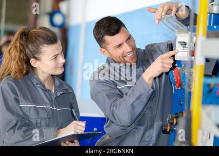 ouvriers ajustant le cadran sur la machine Banque D'Images