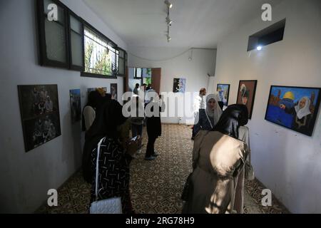 Gaza, Palestine. 25 juin 2023. Les Palestiniens regardent une exposition d'art présentant des peintures intitulées « le droit du retour » à Khan Yunis, dans le sud de la bande de Gaza. (Image de crédit : © Yousef Masoud/SOPA Images via ZUMA Press Wire) USAGE ÉDITORIAL SEULEMENT! Non destiné à UN USAGE commercial ! Banque D'Images