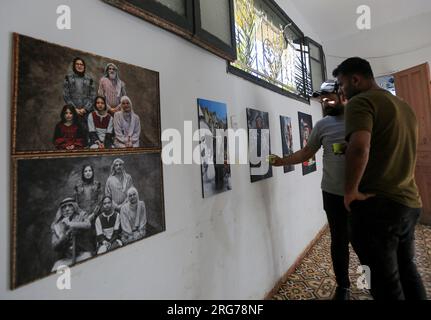 Gaza, Palestine. 25 juin 2023. Les Palestiniens regardent une exposition d'art présentant des peintures intitulées « le droit du retour » à Khan Yunis, dans le sud de la bande de Gaza. (Image de crédit : © Yousef Masoud/SOPA Images via ZUMA Press Wire) USAGE ÉDITORIAL SEULEMENT! Non destiné à UN USAGE commercial ! Banque D'Images