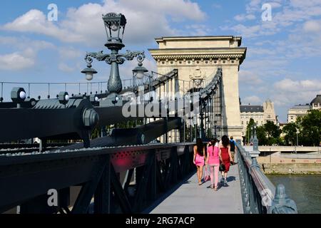 Vue en perspective du pont des chaînes rénové. Bateau d'excursion sur le Danube. Le côté Pest en arrière-plan. la rouvrir au public, les gens marchent. Banque D'Images