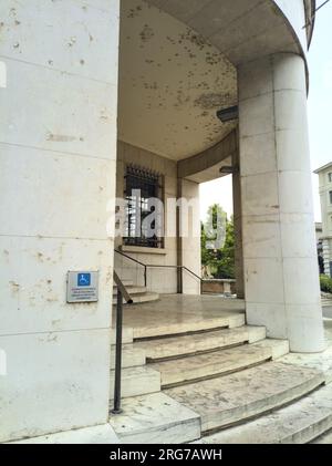 Entrée d'un immeuble avec colonnes et escalier sur une place d'une ville italienne Banque D'Images