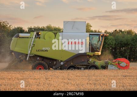 Langtoft, Lincolnshire, Royaume-Uni. 7 août 2023 UK Météo. Les agriculteurs profitent d'une pause dans le temps et récoltent de l'orge sous le soleil de fin de soirée dans le Lincolnshire crédit photo : Tim Scrivener/Alamy Live News Banque D'Images