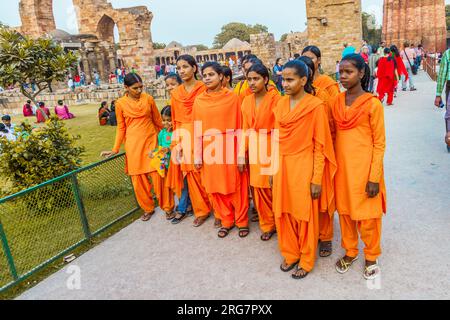 Delhi, Inde - 13 novembre 2011 : groupe de filles d'école posent devant Qutb Minar, le plus haut minaret en briques du monde construit à 72m, construit entre 1193 Banque D'Images