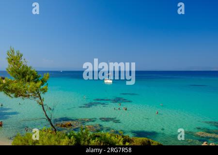 Kavourotrypes, Grèce - 14 août 2017 : vue d'un seul voilier et touristes profitant de la magnifique plage turquoise de Kavourotrypes Banque D'Images