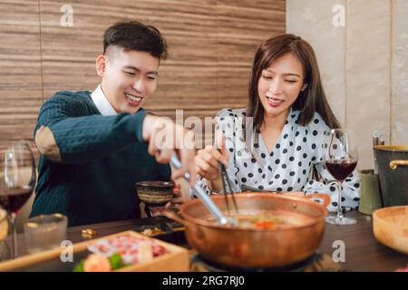 Heureux couple dînant dans le restaurant Hotpots Banque D'Images