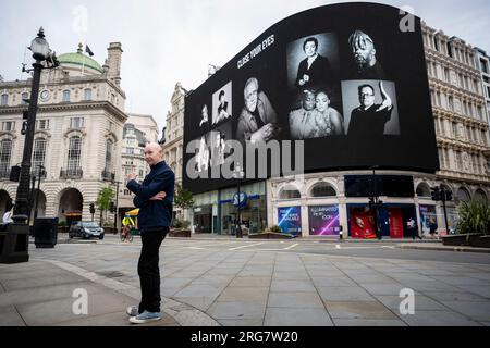 Londres, Royaume-Uni. 8 août 2023. L’artiste photographe Ray Burmiston lors du lancement de « Art of London Presents Take A moment 2023 », sa nouvelle exposition photographique présentant des centaines de visages célèbres les yeux fermés pour sensibiliser à la santé mentale. Des visages, dont Brian Cox et Idris Elba, sont vus sur les grands écrans du Piccadilly Circus, avant une exposition à la National Portrait Gallery en septembre. Crédit : Stephen Chung / Alamy Live News Banque D'Images