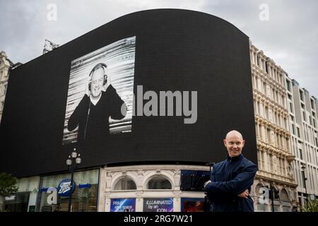 Londres, Royaume-Uni. 8 août 2023. L’artiste photographe Ray Burmiston lors du lancement de « Art of London Presents Take A moment 2023 », sa nouvelle exposition photographique présentant des centaines de visages célèbres les yeux fermés pour sensibiliser à la santé mentale. Des visages, dont Fatboy Slim, sont vus sur les grands écrans du Piccadilly Circus, avant une exposition à la National Portrait Gallery en septembre. Crédit : Stephen Chung / Alamy Live News Banque D'Images