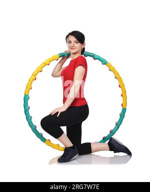 Fitness petite fille à genoux avec la couleur du hula hoop Banque D'Images