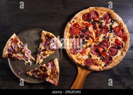 Plan plat d'une pizza fraîchement cuite sur une planche de bois Banque D'Images