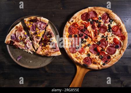 Plan plat d'une pizza fraîchement cuite sur une planche de bois Banque D'Images