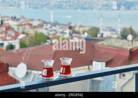 Deux verres turcs en forme de tulipe remplie de thé noir chaud avec vue sur les toits du quartier d'Uskudar sur le côté asiatique d'Istanbul, Turquie Banque D'Images