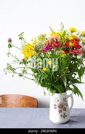 Bouquet d'été de Zinnia colorée, inflorescences d'oignon et brins de menthe, Rudbeckia Goldquelle et trèfle rouge, Ranunculus et Matricaria Banque D'Images