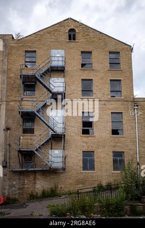 Marches d'évacuation en métal bleu à l'extérieur de l'ancien bâtiment d'entrepôt abandonné à Bradford, Angleterre Royaume-Uni. 2023. Banque D'Images