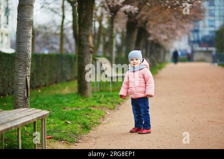 Adorable petite fille marchant dans le parc le jour d'hiver ou de printemps, Paris, France Banque D'Images