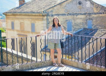 Portrait de femme d'âge moyen touriste visitant la ville. Heureuse femme âgée dans une rue du village de Bonnieux en Provence, France. Voyageuse mature dans Banque D'Images