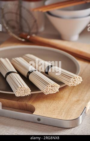 Nouilles udon de blé crues sur l'assiette, cuisine orientale et asiatique Banque D'Images