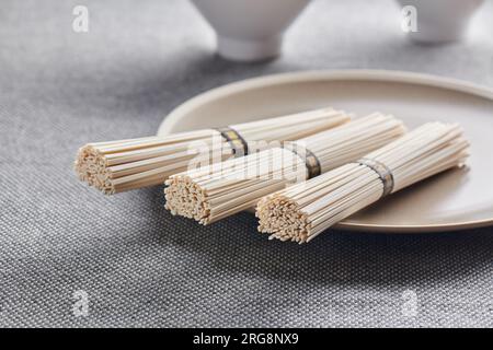 Nouilles udon de blé crues sur l'assiette, cuisine orientale et asiatique Banque D'Images