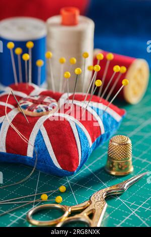 Coussinet comme Union Jack sur tapis d'artisanat vert, accessoires de couture Banque D'Images