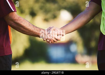 Poignée de main, équipe de rugby et défi des hommes, entraînement d'exercice ou coopération dans le sport de plein air. Serrer la main, le partenariat et les athlètes Banque D'Images