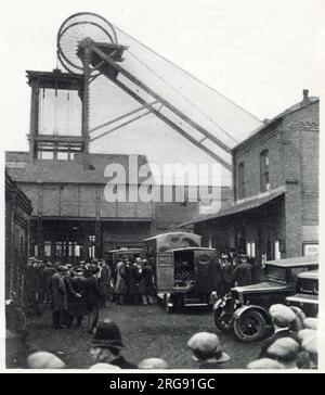 Bickershaw Colliery dans le Lancashire où la catastrophe de la mine de charbon s'est produite le 10 octobre 1932. Un ascenseur de puits de mine transportant 20 personnes est tombé à la mine, tuant toutes les personnes sauf une. Scène à la tête de fosse après l'explosion dans la mine, groupe de personnes anxieuses, avec ambulance-van en préparation. Banque D'Images