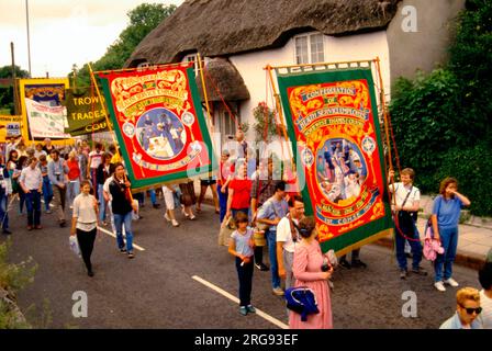 Personnes participant au Tolpuddle Rally Festival, Dorset, un événement annuel commémorant les martyrs de Tolpuddle de 1834. Les bannières comprennent celles de la Confédération des employés des services de santé (COHSE), North West Thames et Oxford, South West Thames et Wessex. Banque D'Images