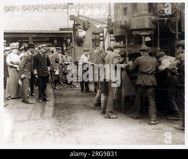 Le roi George V (1865-1936) et la reine Mary (1867-1953) visitent un atelier d'usine lors d'une visite des comtés du Nord-est de l'Angleterre. Banque D'Images