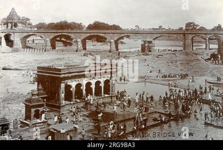 Nashik - une ancienne ville sainte dans la région nord de l'état indien du Maharashtra. Situé sur les rives de la rivière Godavari - cette carte montre le pont en pierre fine sur la rivière et les fidèles se baignant dans les eaux. Nasik est bien connu pour être l'un des lieux de pèlerinage hindou, celui de Kumbh Mela qui a lieu tous les 12 ans. Banque D'Images