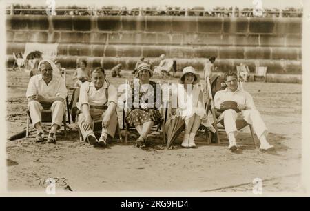 Une belle photo de groupe de cinq amis (ou parents) assis sur des transats sur la plage à Margate, dans le Kent. Banque D'Images