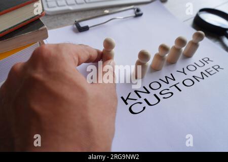 Poupée en bois à la main sur presse-papiers avec texte CONNAÎTRE VOTRE CLIENT. Concept commercial Banque D'Images