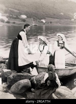 Photographie vintage du 19th siècle : jeune femme norvégienne en robe traditionnelle grimpant hors d'un bateau. Banque D'Images