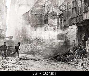 Photographie d'époque Seconde Guerre mondiale - combats dans les rues de Cologne Allemagne, près de la cathédrale, char américain frappé par une coquille Banque D'Images