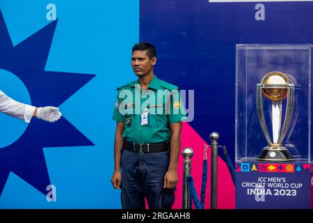 Dhaka, Bangladesh. 08 août 2023. Un policier pose pour une photo à côté du trophée de la coupe du monde de cricket masculin de la CPI exposé au stade national Sher-e-Bangla à Mirpur, Dhaka. La tournée des trophées de la coupe du monde de cricket masculin ICC au Bangladesh se déroule du 07 au 09 août 2023. (Photo de Sazzad Hossain/SOPA Images/Sipa USA) crédit : SIPA USA/Alamy Live News Banque D'Images