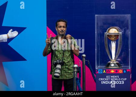 Dhaka, Bangladesh. 08 août 2023. Un photojournaliste pose pour une photo à côté du trophée de la coupe du monde de cricket masculin ICC exposé au stade national Sher-e-Bangla à Mirpur, Dhaka. La tournée des trophées de la coupe du monde de cricket masculin ICC au Bangladesh se déroule du 07 au 09 août 2023. (Photo de Sazzad Hossain/SOPA Images/Sipa USA) crédit : SIPA USA/Alamy Live News Banque D'Images