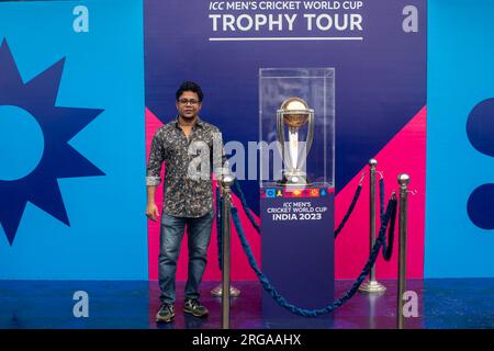 Dhaka, Bangladesh. 08 août 2023. Un journaliste sportif pose pour une photo à côté du trophée de la coupe du monde de cricket masculin ICC exposé au stade national Sher-e-Bangla à Mirpur, Dhaka. La tournée des trophées de la coupe du monde de cricket masculin ICC au Bangladesh se déroule du 07 au 09 août 2023. (Photo de Sazzad Hossain/SOPA Images/Sipa USA) crédit : SIPA USA/Alamy Live News Banque D'Images