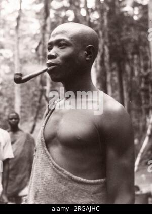 1940s Afrique de l'est Ouganda - forêt de Budongo, abattage et sciage d'acajou - un homme de bois avec sa pipe Photographie par un officier de recrutement de l'armée britannique stationné en Afrique de l'est et au Moyen-Orient pendant la Seconde Guerre mondiale Banque D'Images