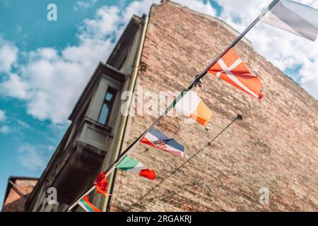 De nombreux drapeaux de pays suspendus à un plafond sur des cordes à l'heure d'été Banque D'Images