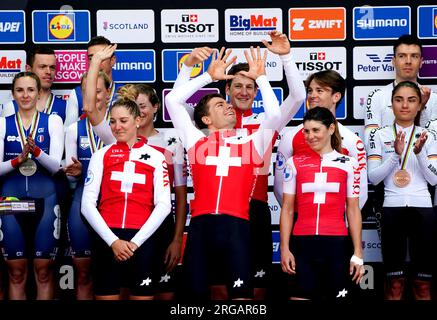 Les Suisses Stefan Bissegger, Stefan Kung, Mauro Schmid, Elise Chabbey, Nicole Koller et Marlen Reusser célèbrent sur le podium avant de recevoir leurs médailles d'or après avoir remporté le relais mixte contre la montre par équipes lors de la sixième journée des Championnats du monde de cyclisme UCI 2023 à Glasgow. Date de la photo : mardi 8 août 2023. Banque D'Images