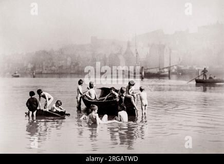 Angleterre Nord-est - Whitby: 'Les rats d'eau' - les garçons jouant dans l'eau sur des bateaux par FM Sutcliffe. Banque D'Images