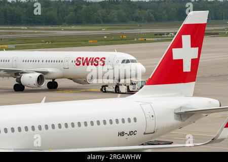 Zurich, Suisse, le 19 mai 2023 HB-IOH compagnies aériennes internationales suisses un Airbus A321-111 est remorqué à travers l'aire de trafic derrière un autre avion suisse Banque D'Images