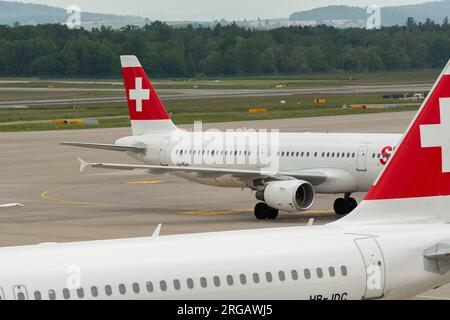 Zurich, Suisse, le 19 mai 2023 HB-IOH compagnies aériennes internationales suisses un Airbus A321-111 est remorqué à travers l'aire de trafic derrière un autre avion suisse Banque D'Images