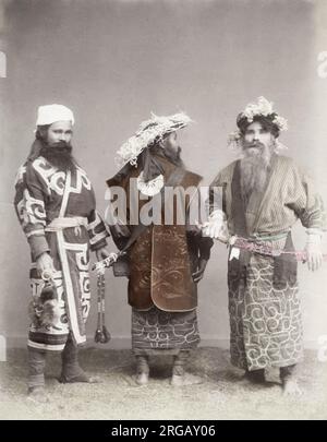 Photographie vintage du XIXe siècle - trois hommes Ainu avec épées dans un cadre de studio, Japon, vers 1880. Banque D'Images