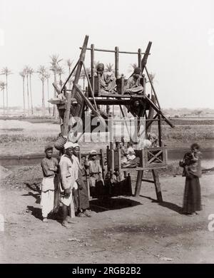 Les enfants lors d'une ancienne fête foraine ride, l'Égypte, c.1890 Banque D'Images