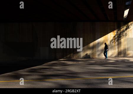 Homme marchant sur le côté marcher dans le tunnel avec ombre inclinée à Toronto Canada Banque D'Images