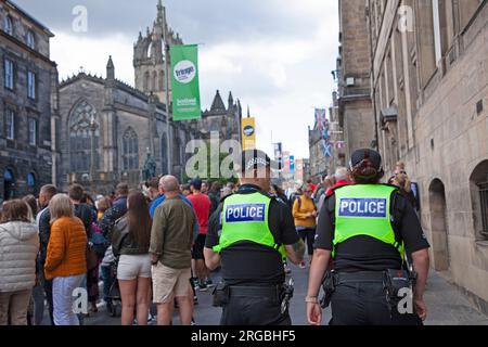 Royal Mile, Édimbourg, Écosse, Royaume-Uni. Journée bien remplie au Edinburgh Fringe Festival, le grand public s'arrête pour regarder et se divertir par les Street Performers sur High Street, aidés par le soleil et le temps plus chaud. Photo : des policiers patrouillent dans High Street. Crédit : Archwhite/alamy Live News. Banque D'Images